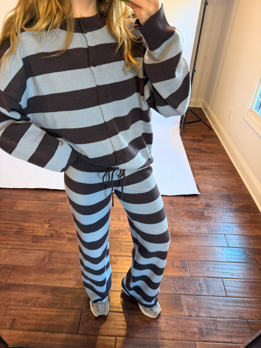 Women wearing a brown and blue matching stripe sweater set.