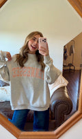 Person wearing a gray sweatshirt with 'Tennessee' printed on it, taking a mirror selfie.