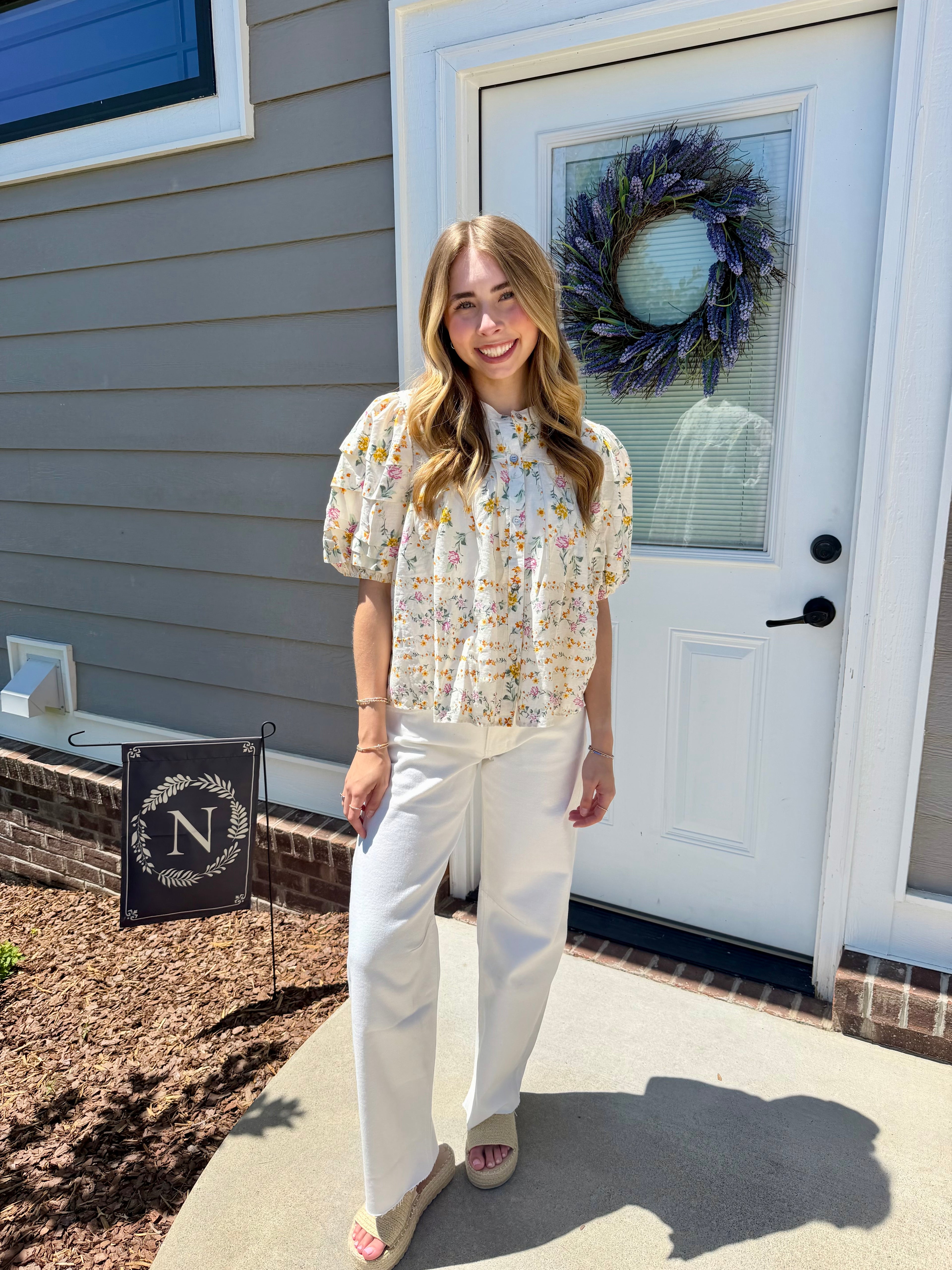 Woman standing outside a house with a wreath on the door