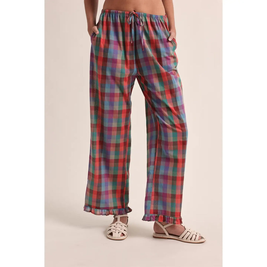 Plaid pants worn by a person on a beige background