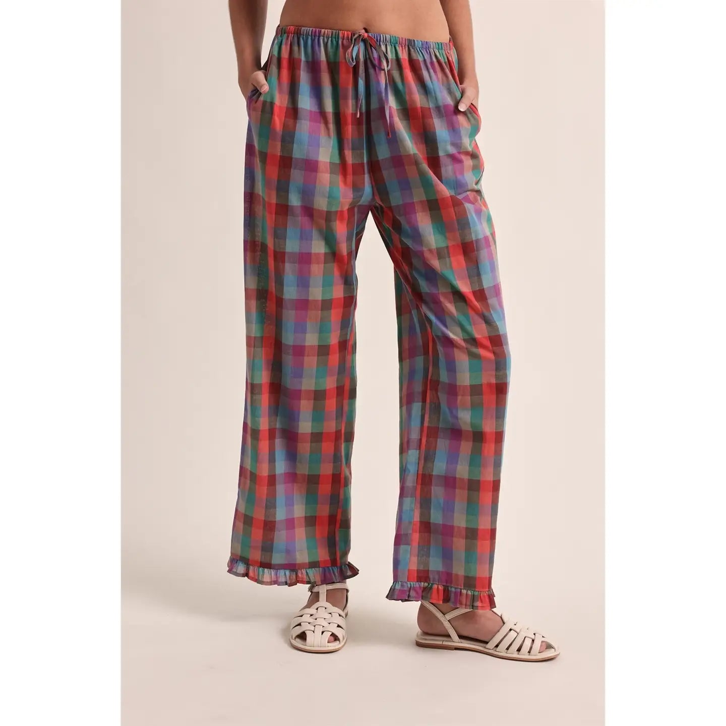 Plaid pants worn by a person on a beige background