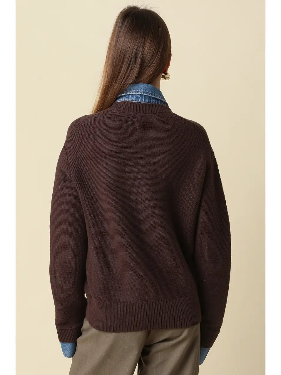 Women wearing a brown and denim sweater with brown pants. 