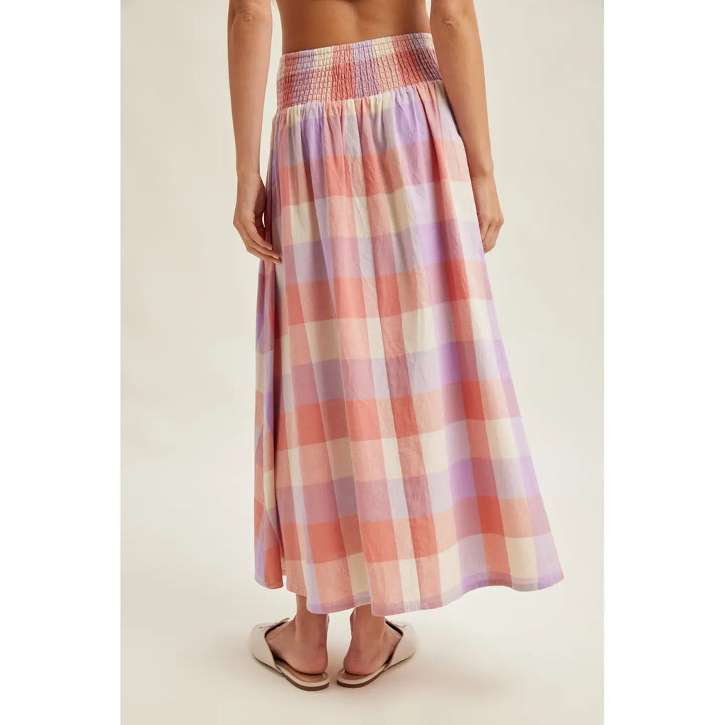 Person wearing a plaid skirt on a plain background