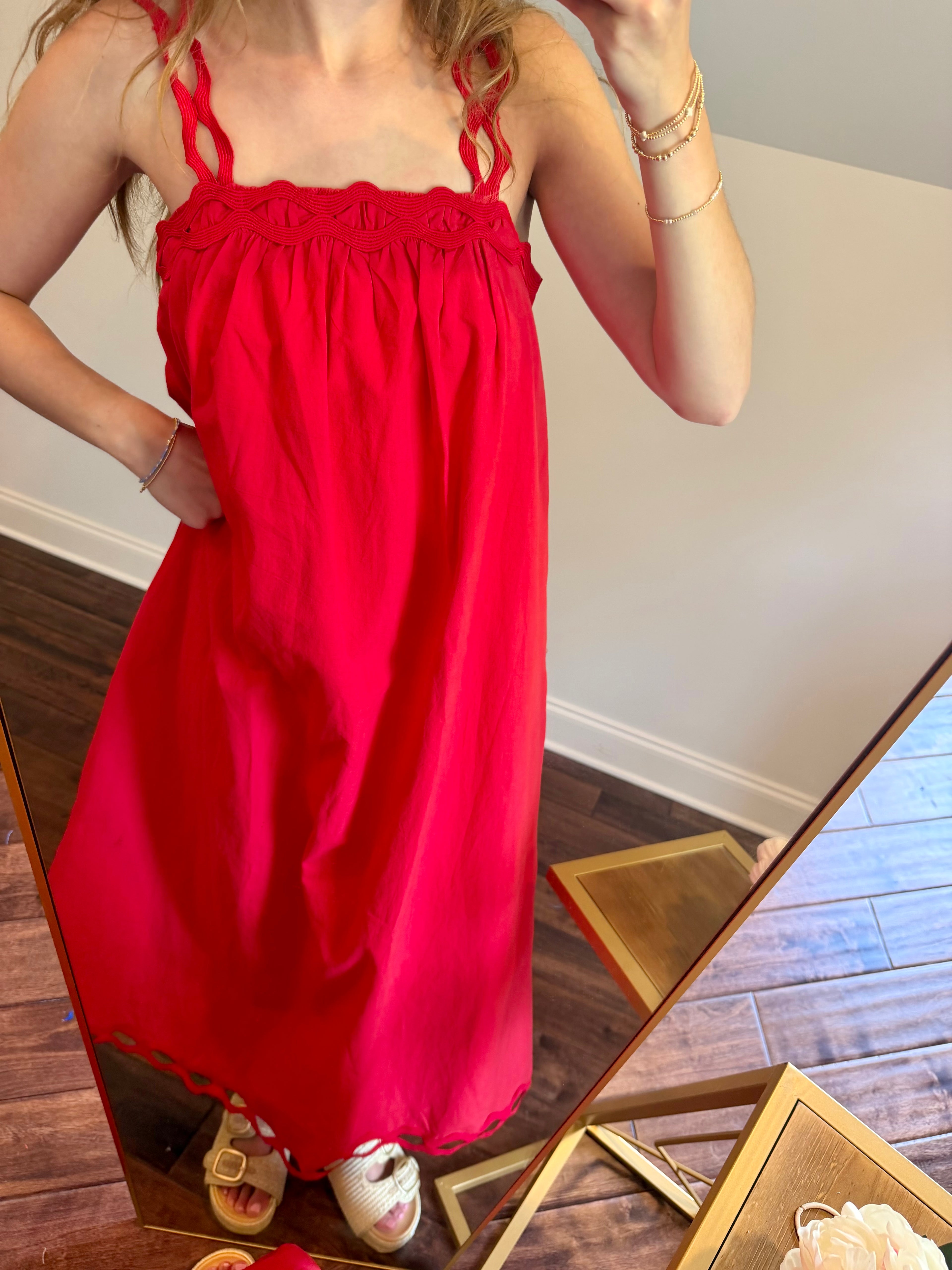 Person wearing a red dress standing in front of a mirror.