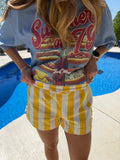Person wearing a colorful t-shirt with fast food graphics and yellow striped shorts.