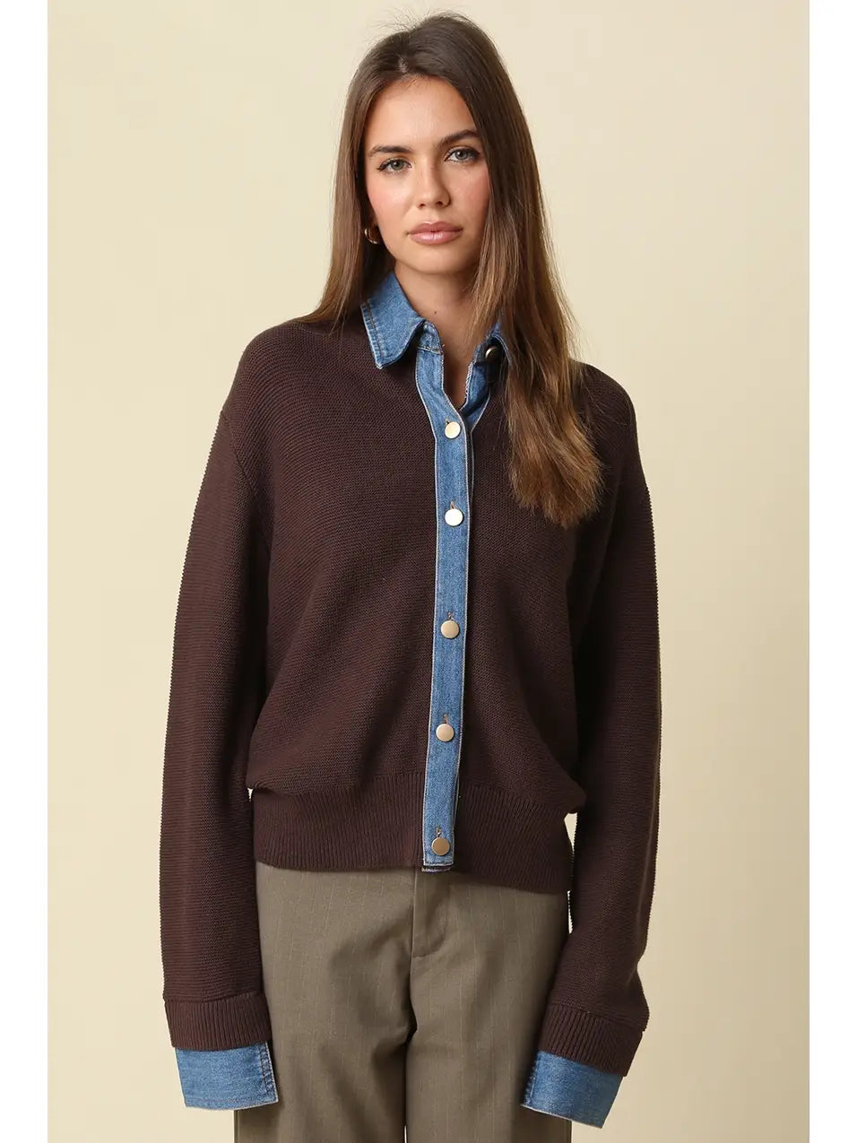Women wearing a brown and denim sweater with brown pants. 