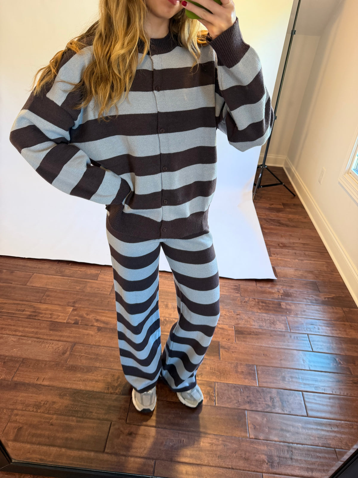 Women wearing a brown and blue matching stripe sweater set.
