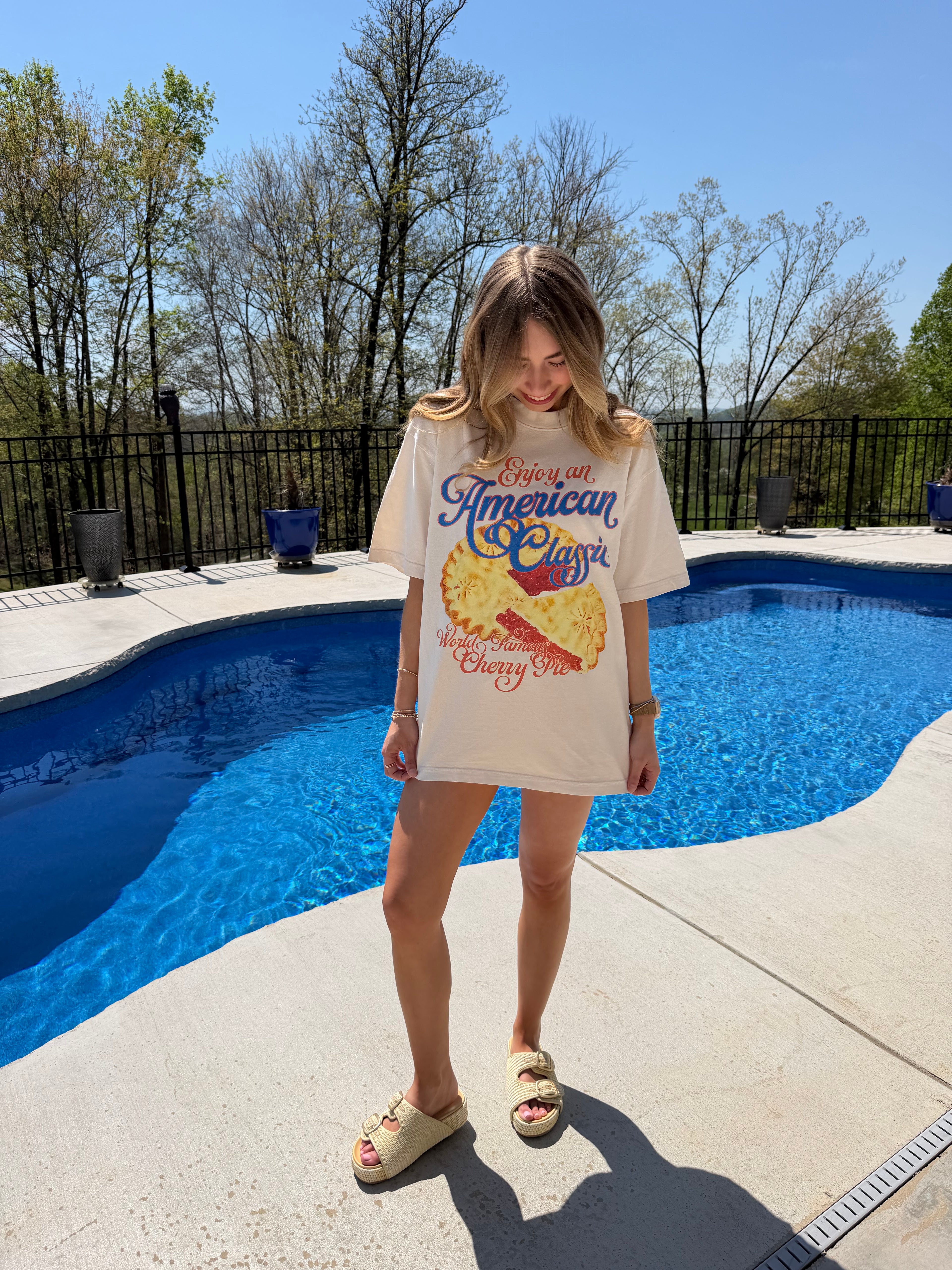 Person wearing a tee with a pie design by a pool