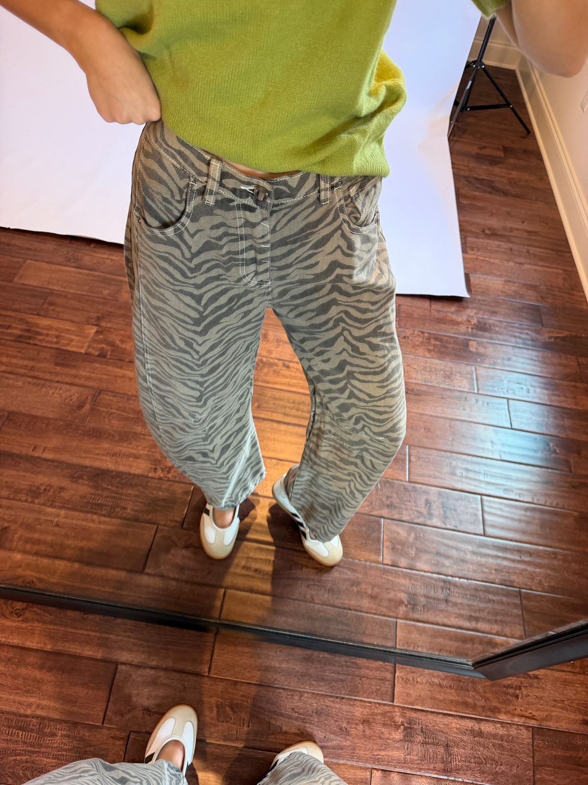 Women wearing a matcha green top with zebra jeans. 