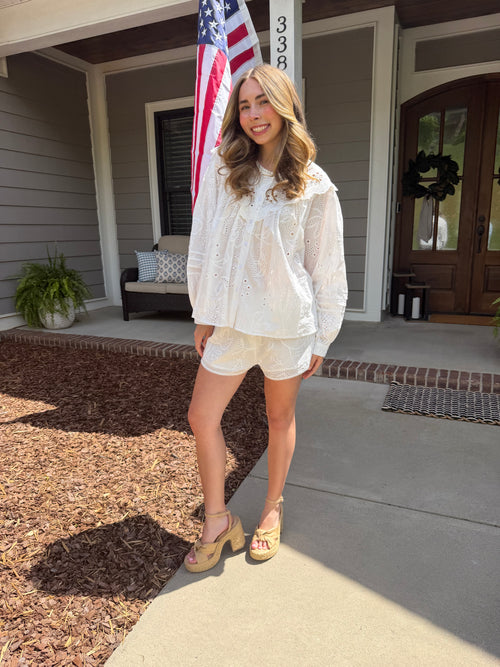 Woman standing on a porch with an American flag in the background