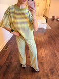 Person wearing a green and white striped outfit standing on a wooden floor.