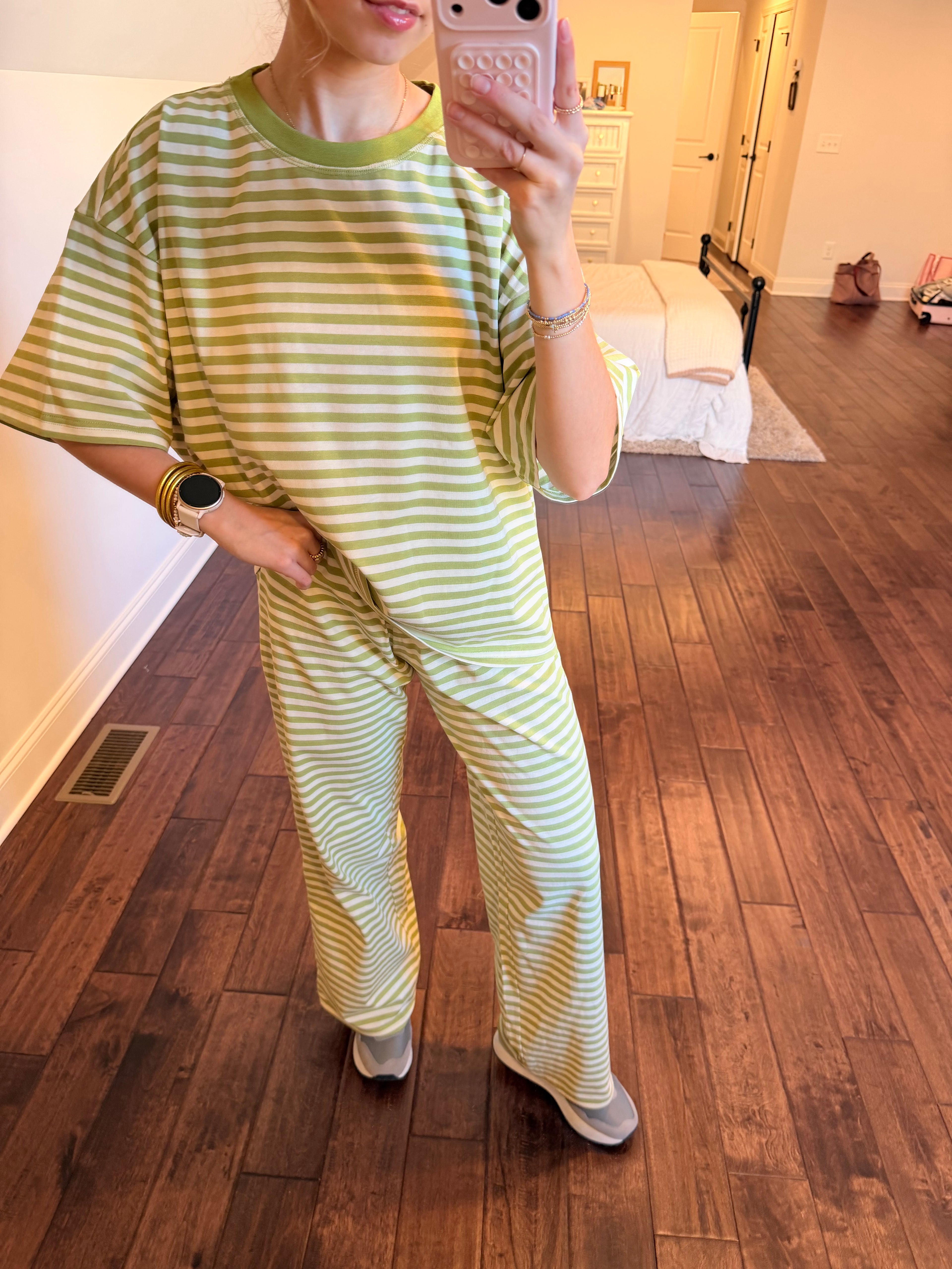 Person wearing a green and white striped outfit standing on a wooden floor.