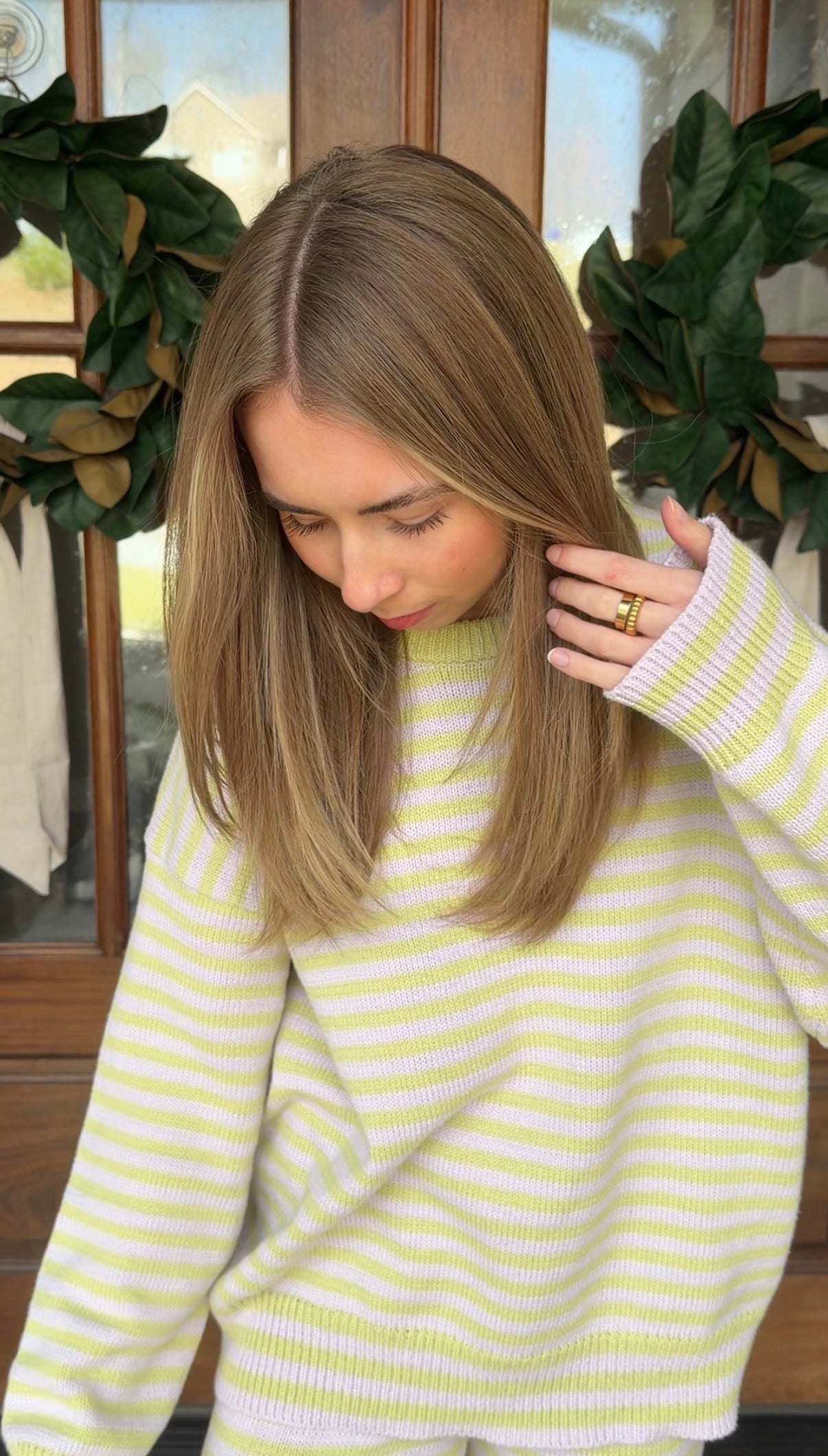 Woman wearing a yellow and white striped sweater with a decorative background