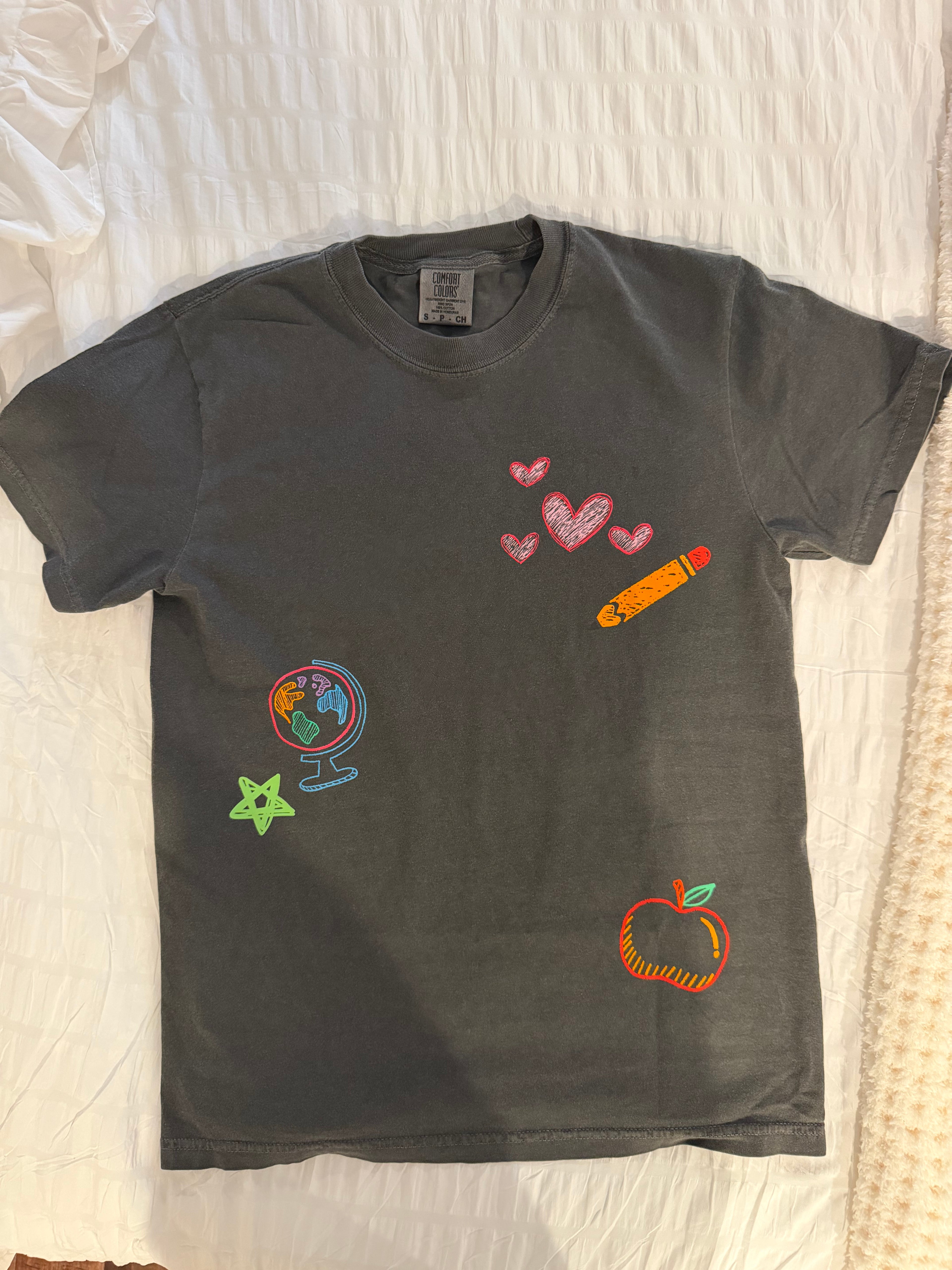 Black t-shirt with colorful graphics on a textured surface
