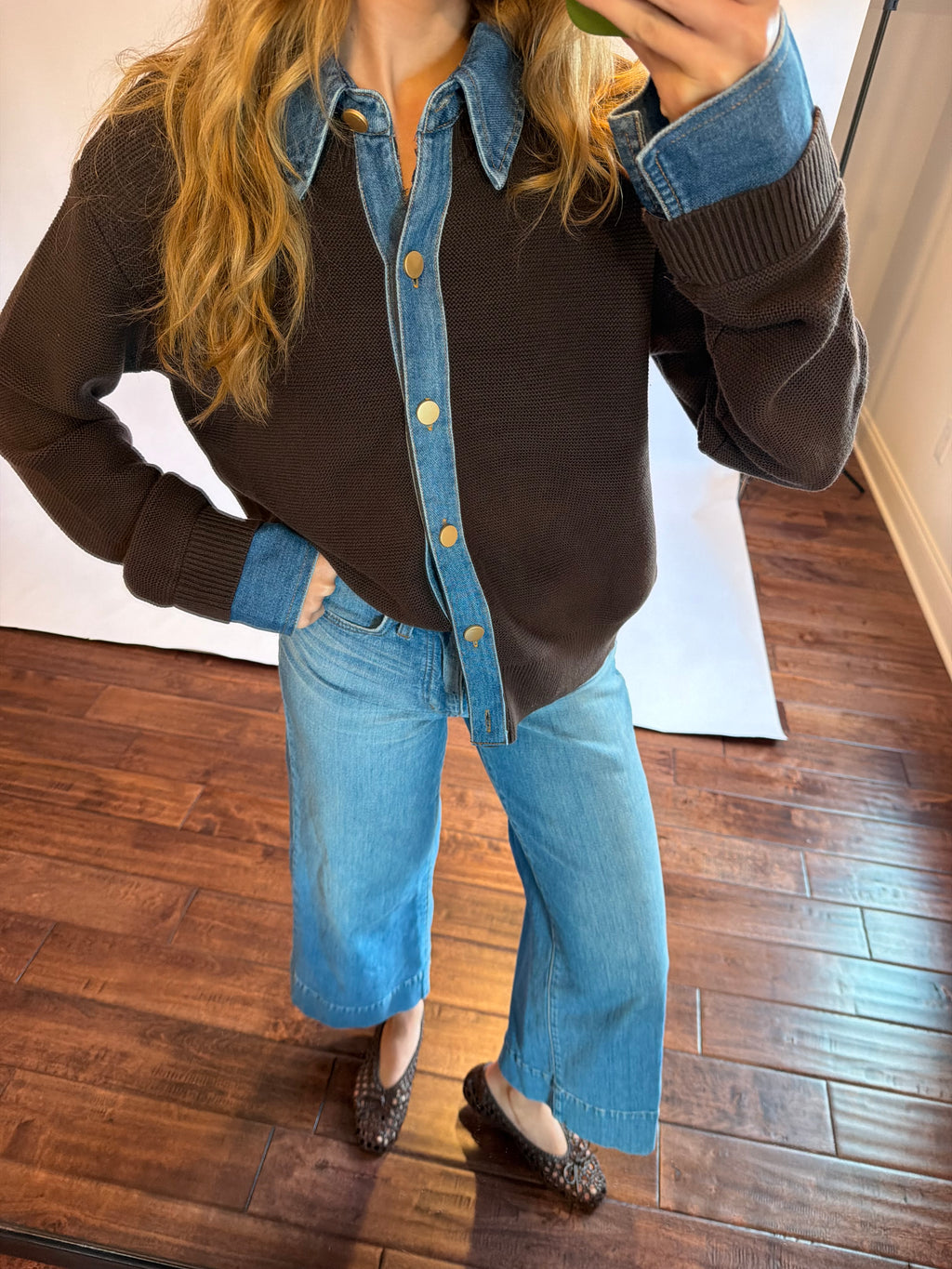 Women wearing a brown and denim sweater with jeans. 