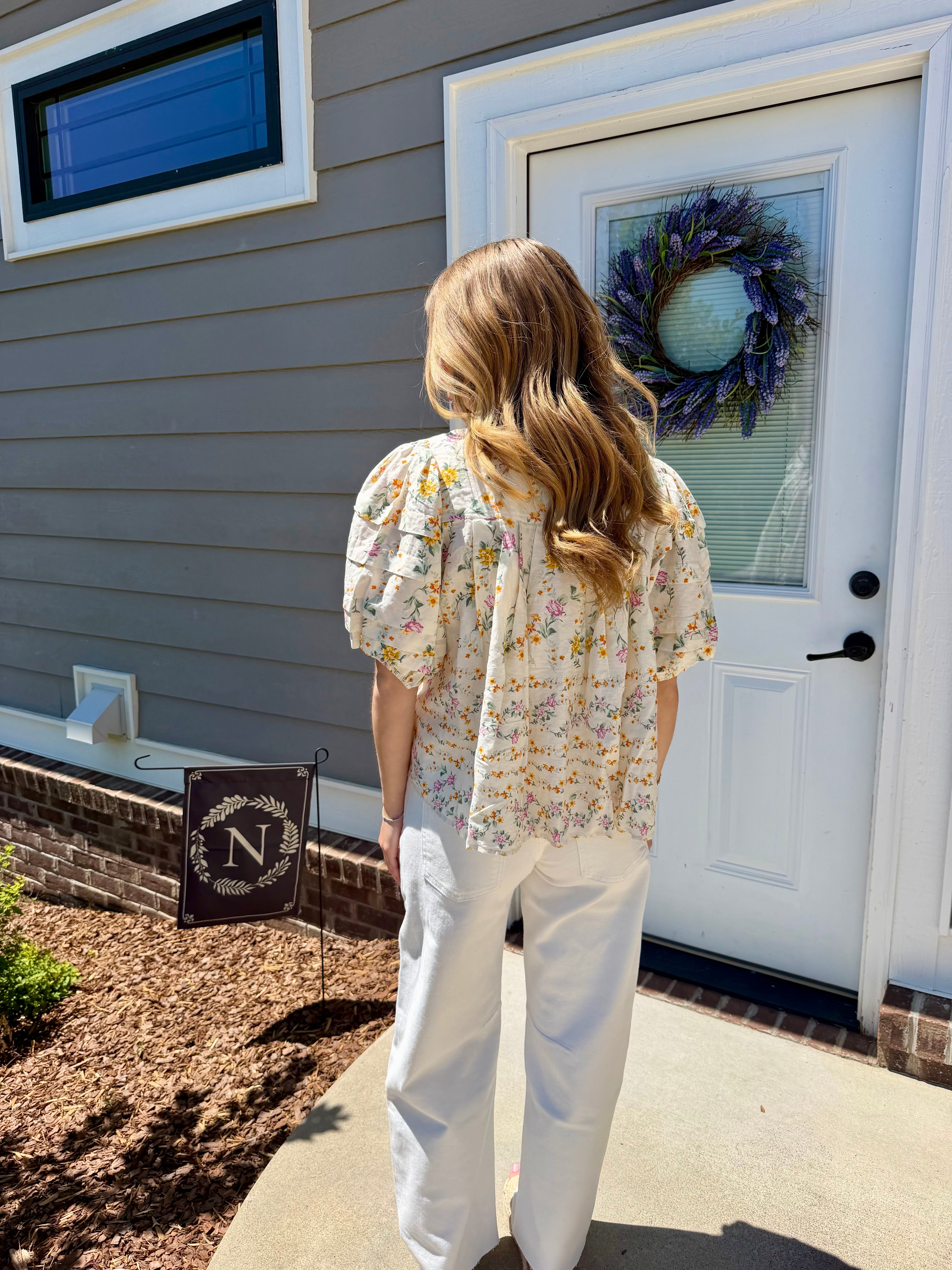 Woman standing outside a house with a wreath on the door