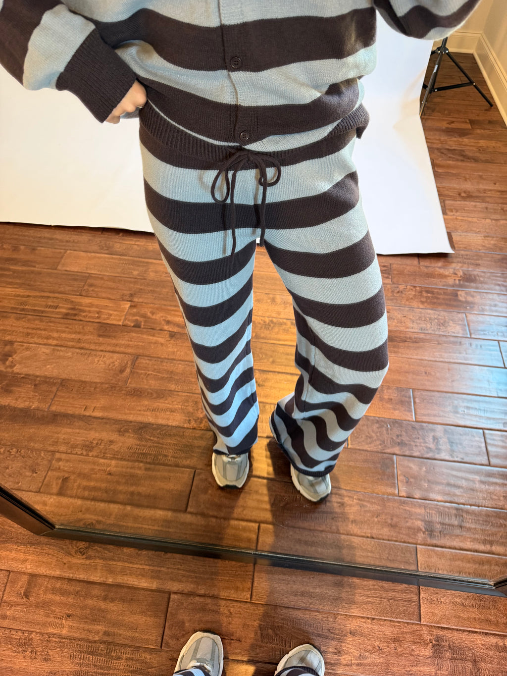 Women wearing a brown and blue matching stripe sweater set.