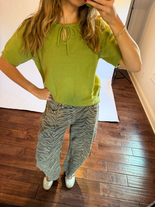 Women wearing a matcha green top with zebra jeans. 