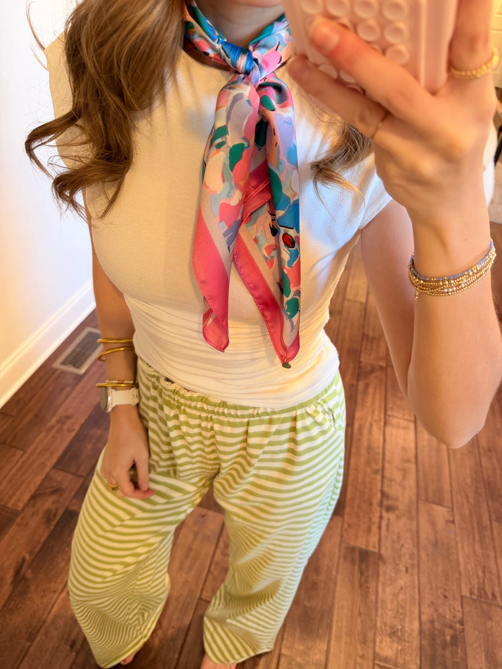 Person wearing a colorful scarf on a wooden floor