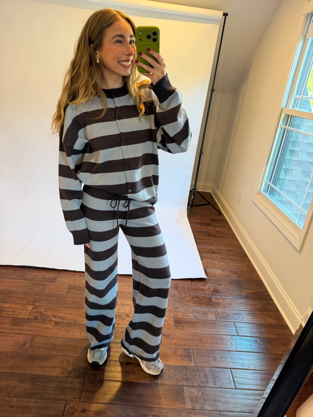 Women wearing a brown and blue matching stripe sweater set.