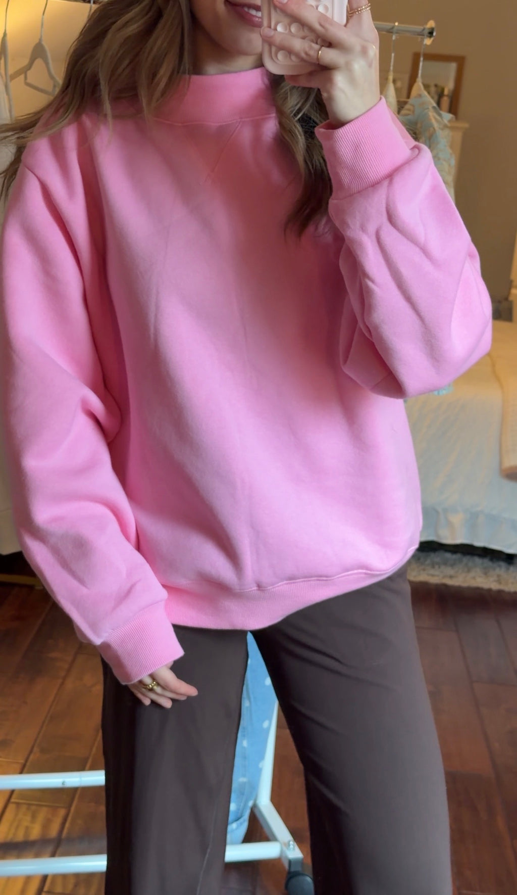 Person wearing a pink sweatshirt in an indoor setting