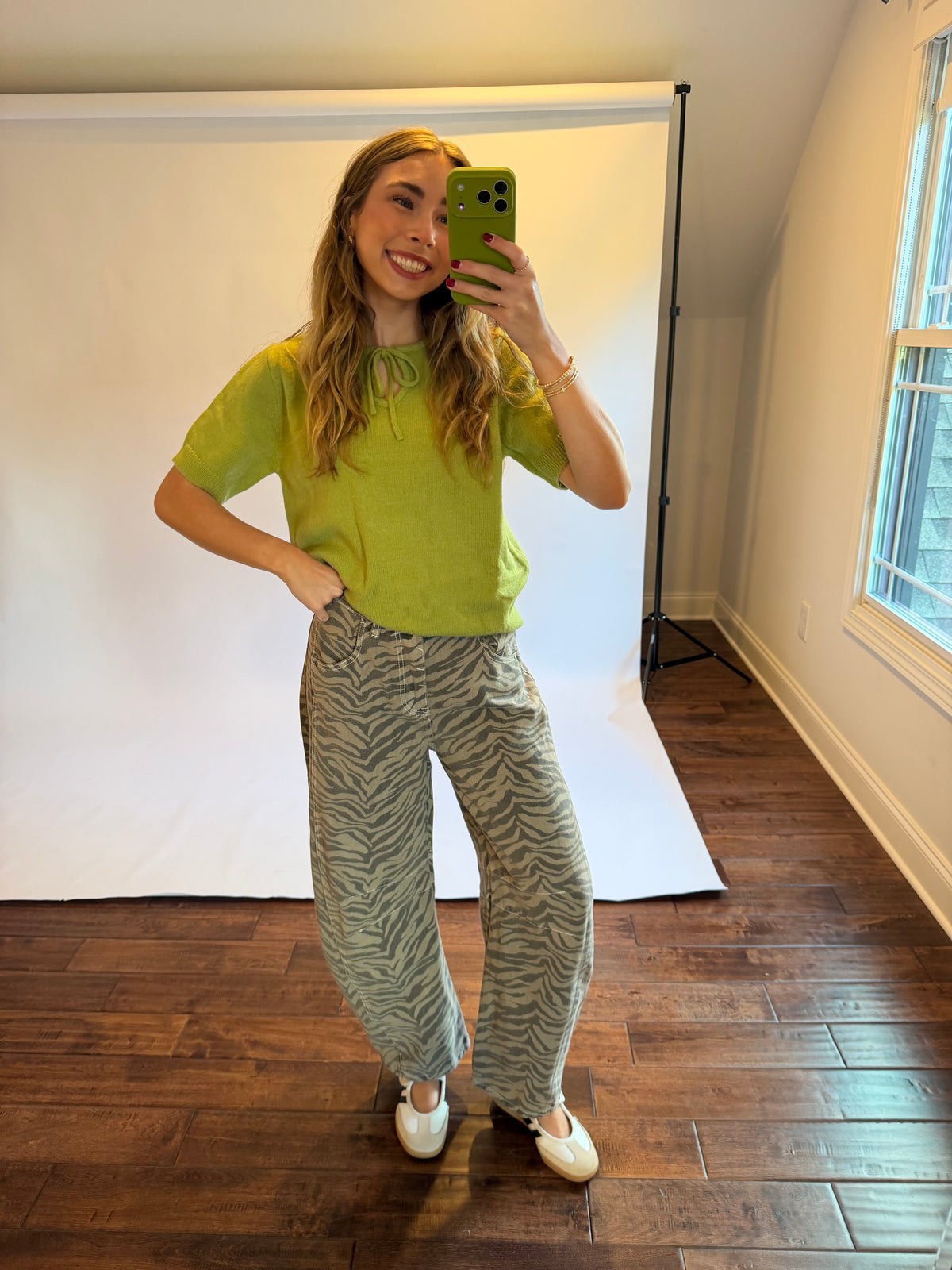 Women wearing a matcha green top with zebra jeans. 