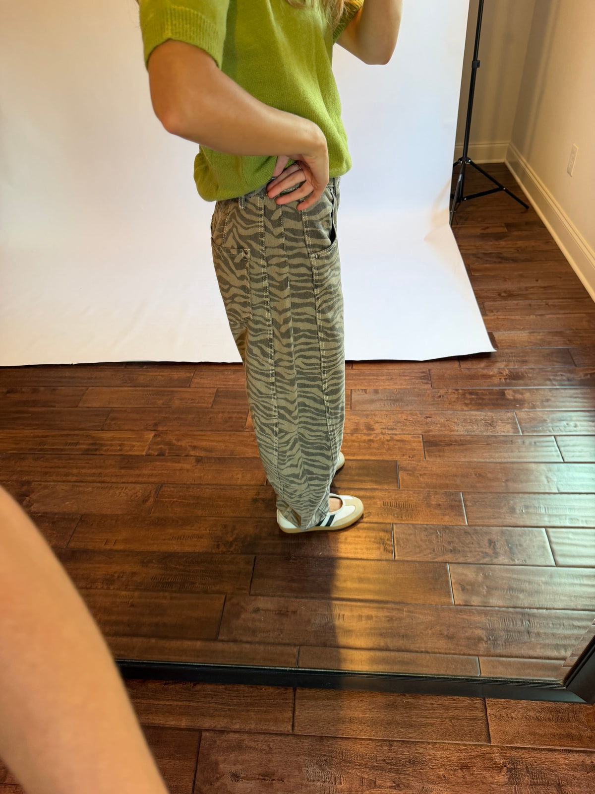 Women wearing a matcha green top with zebra jeans. 