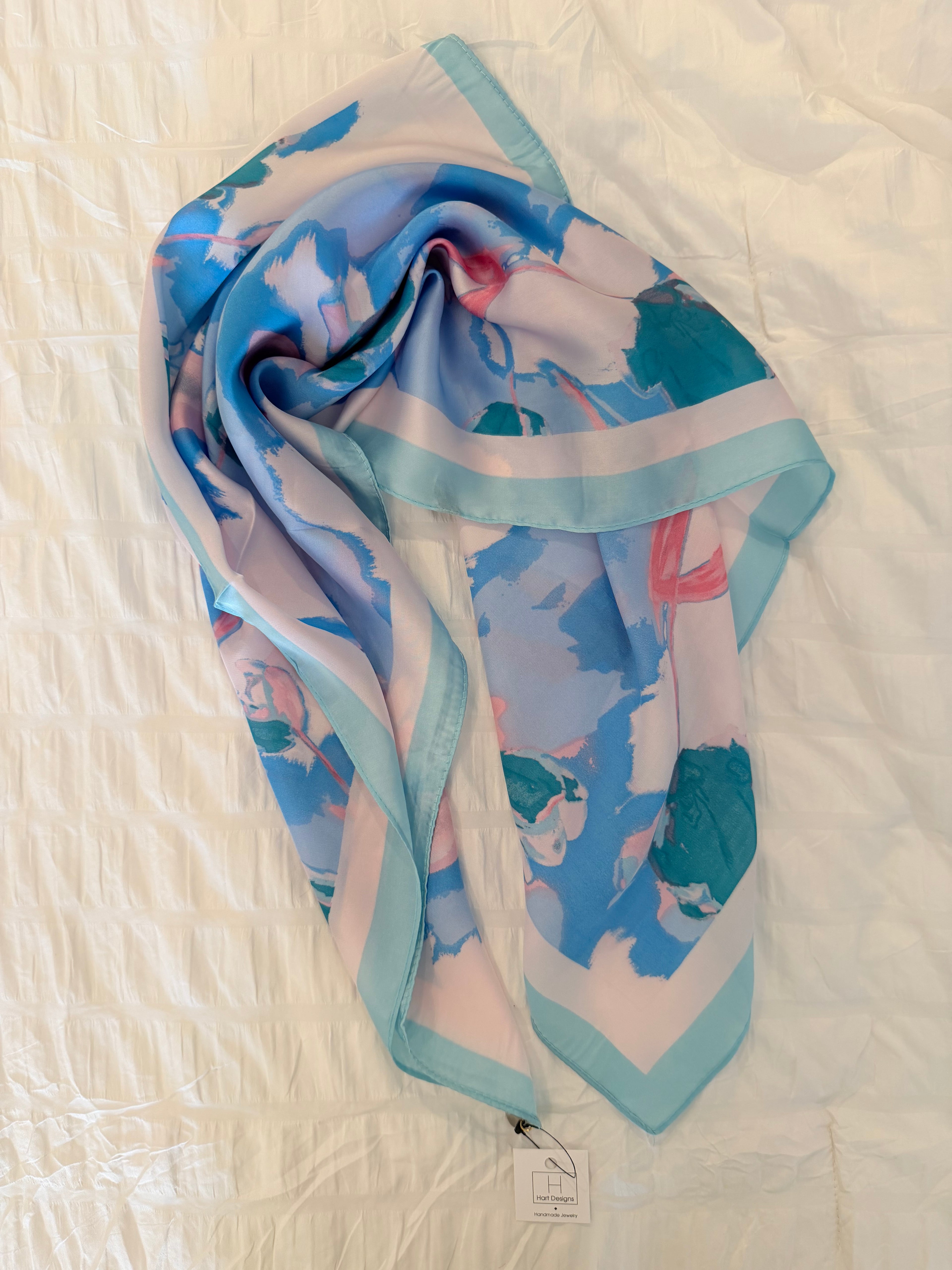 Colorful scarf with floral pattern on a textured white surface