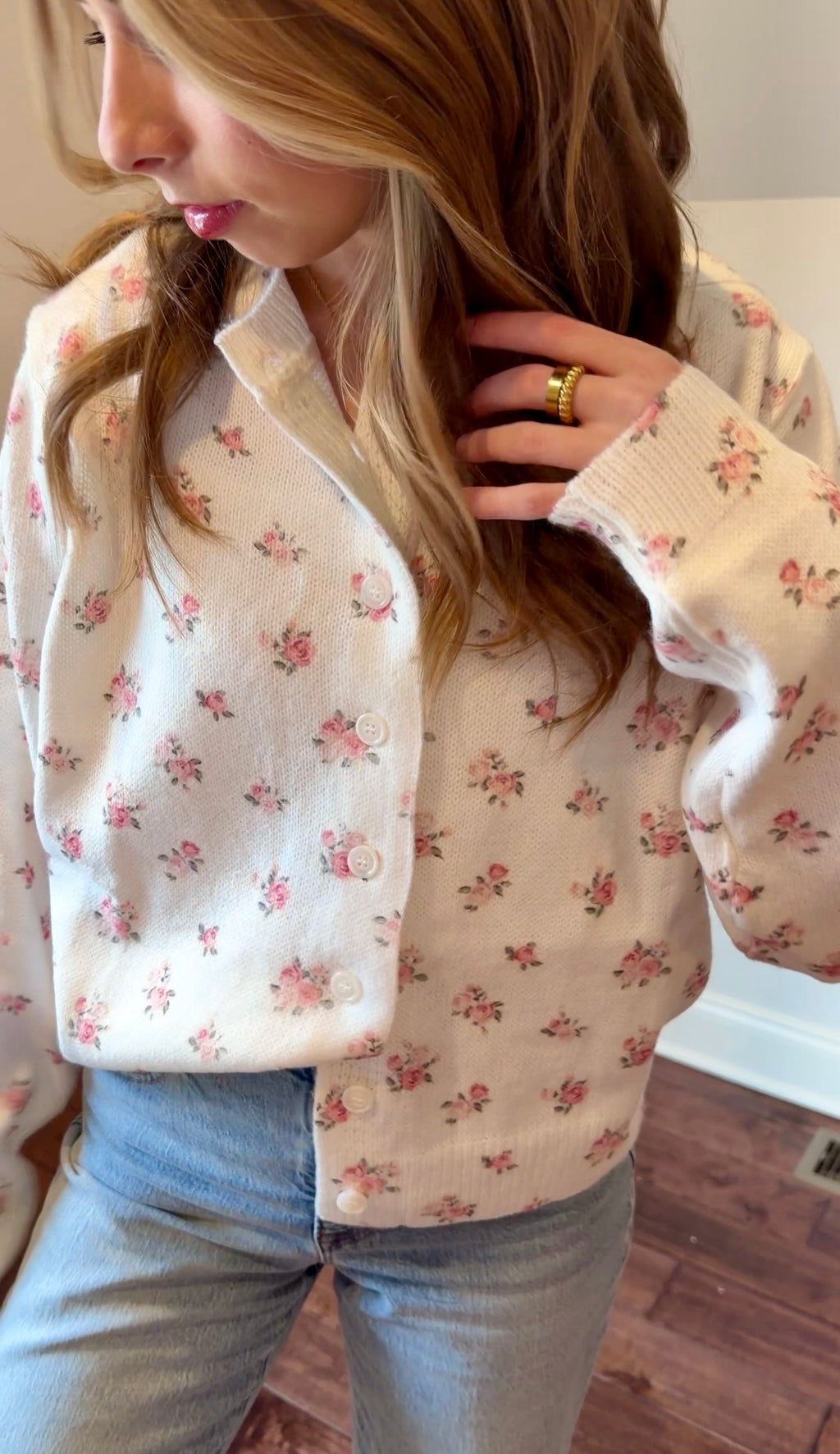 Person wearing a floral-patterned cardigan indoors
