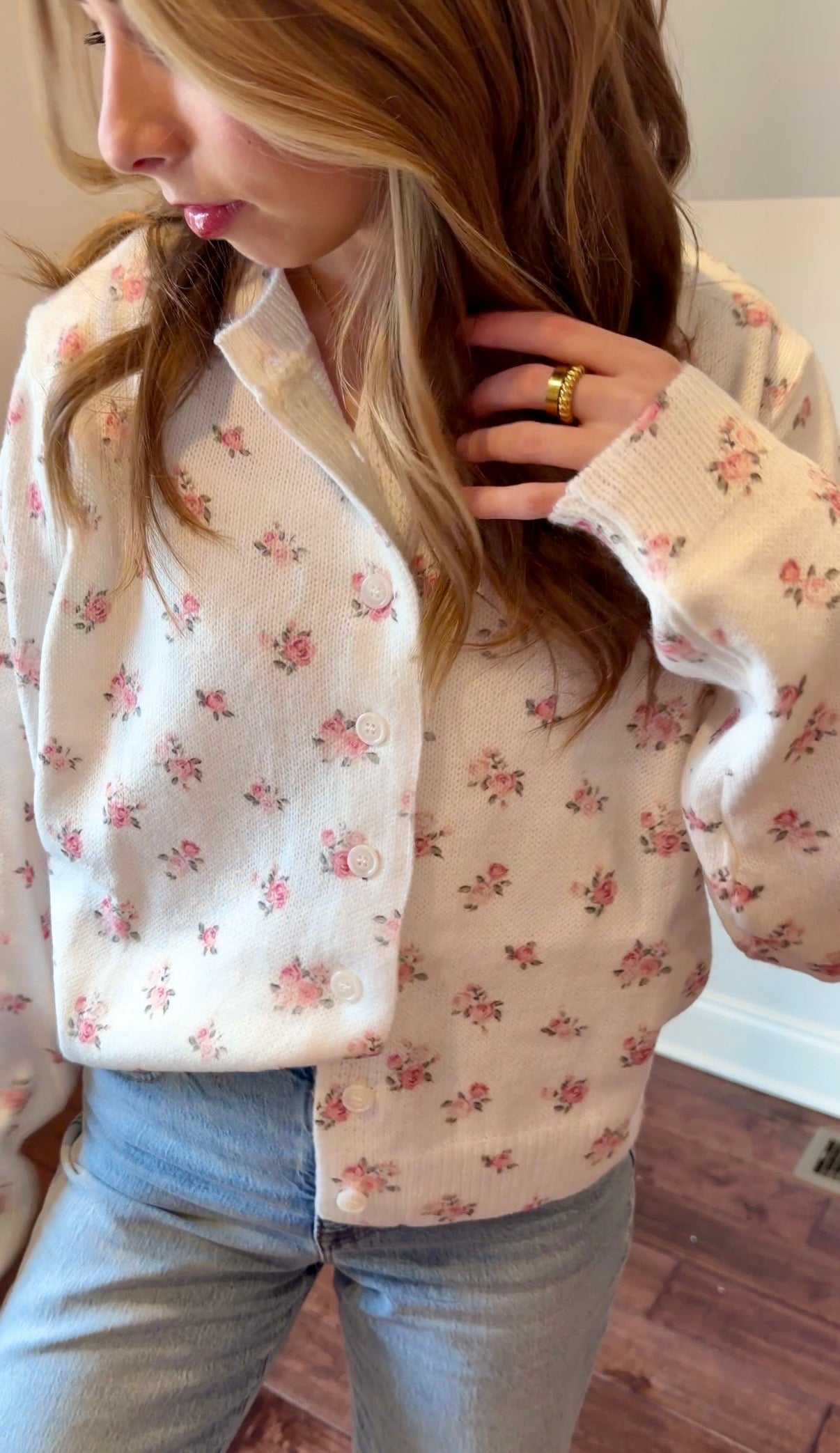 Person wearing a floral-patterned cardigan indoors