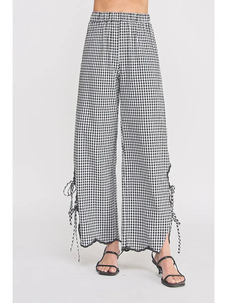 Black and white checkered pants with tie details on a white background