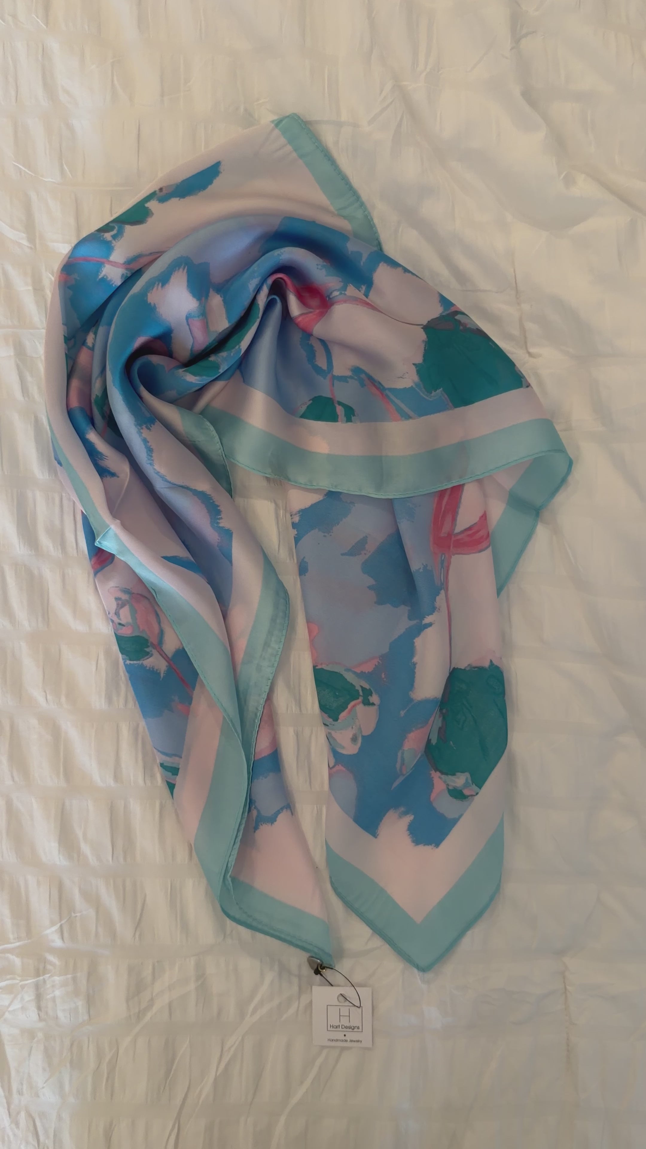 Colorful scarf with floral pattern on a textured white surface