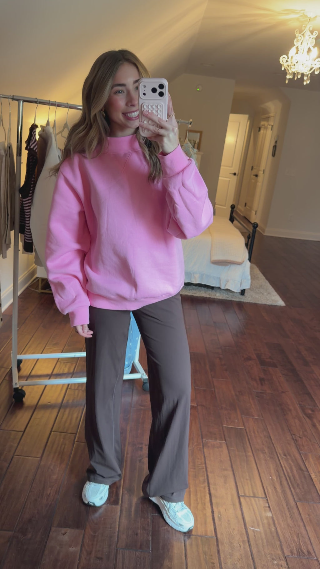 Person wearing a pink sweatshirt and brown pants in an indoor setting