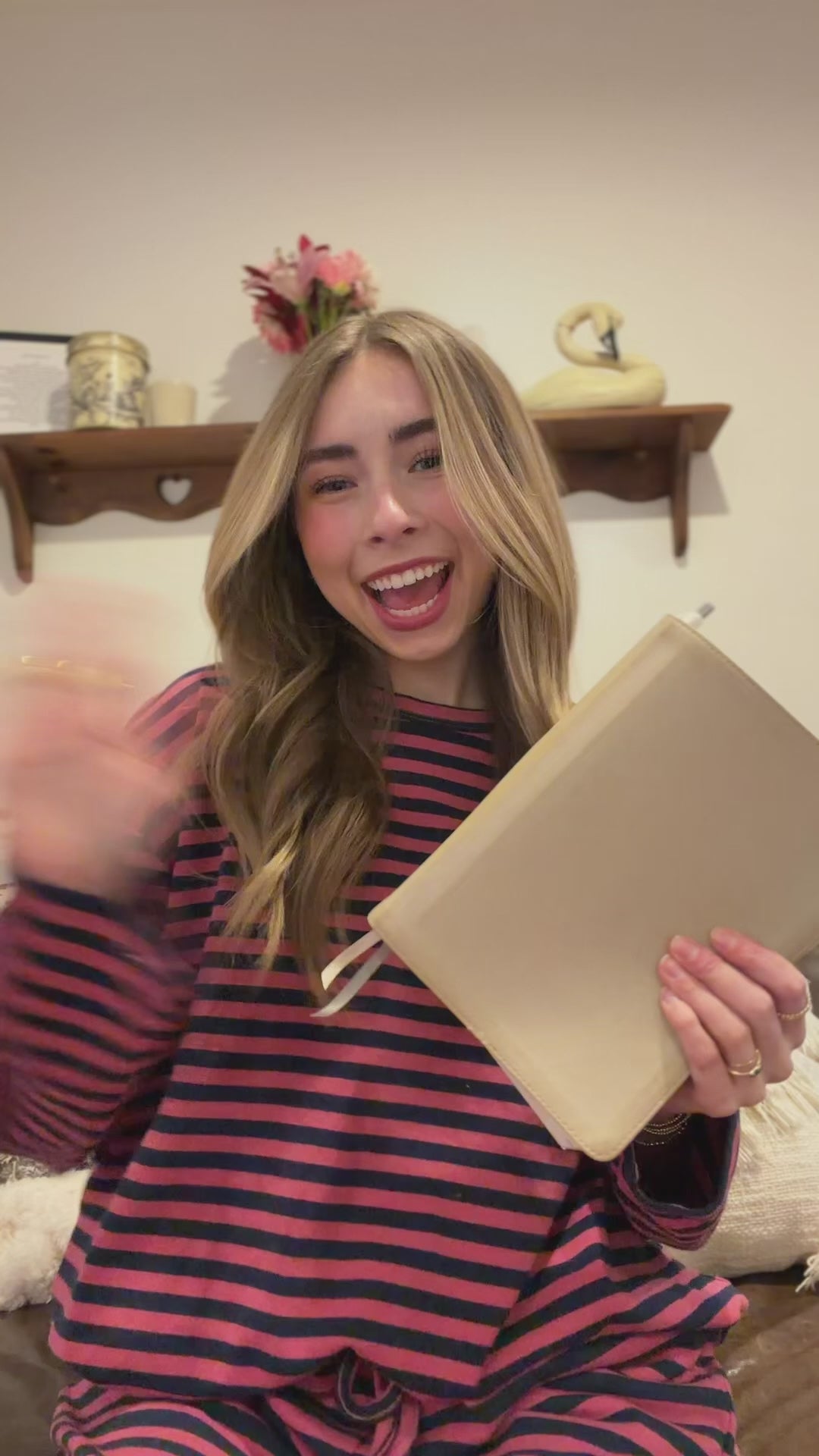 Women in pink and navy stripe outfit sharing a bible verse while holding a bible. 